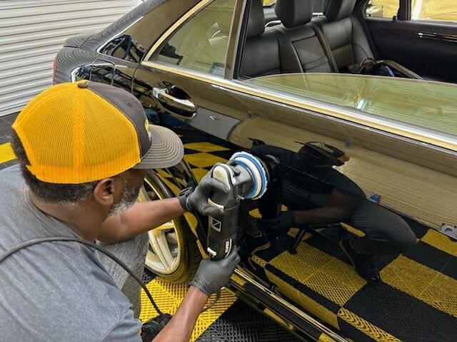 A man is polishing a car with a machine.